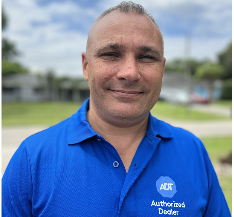 Ray Ferguson, owner of Safe & Secure Florida, wearing a blue ADT Authorized Dealer polo shirt, standing outdoors.